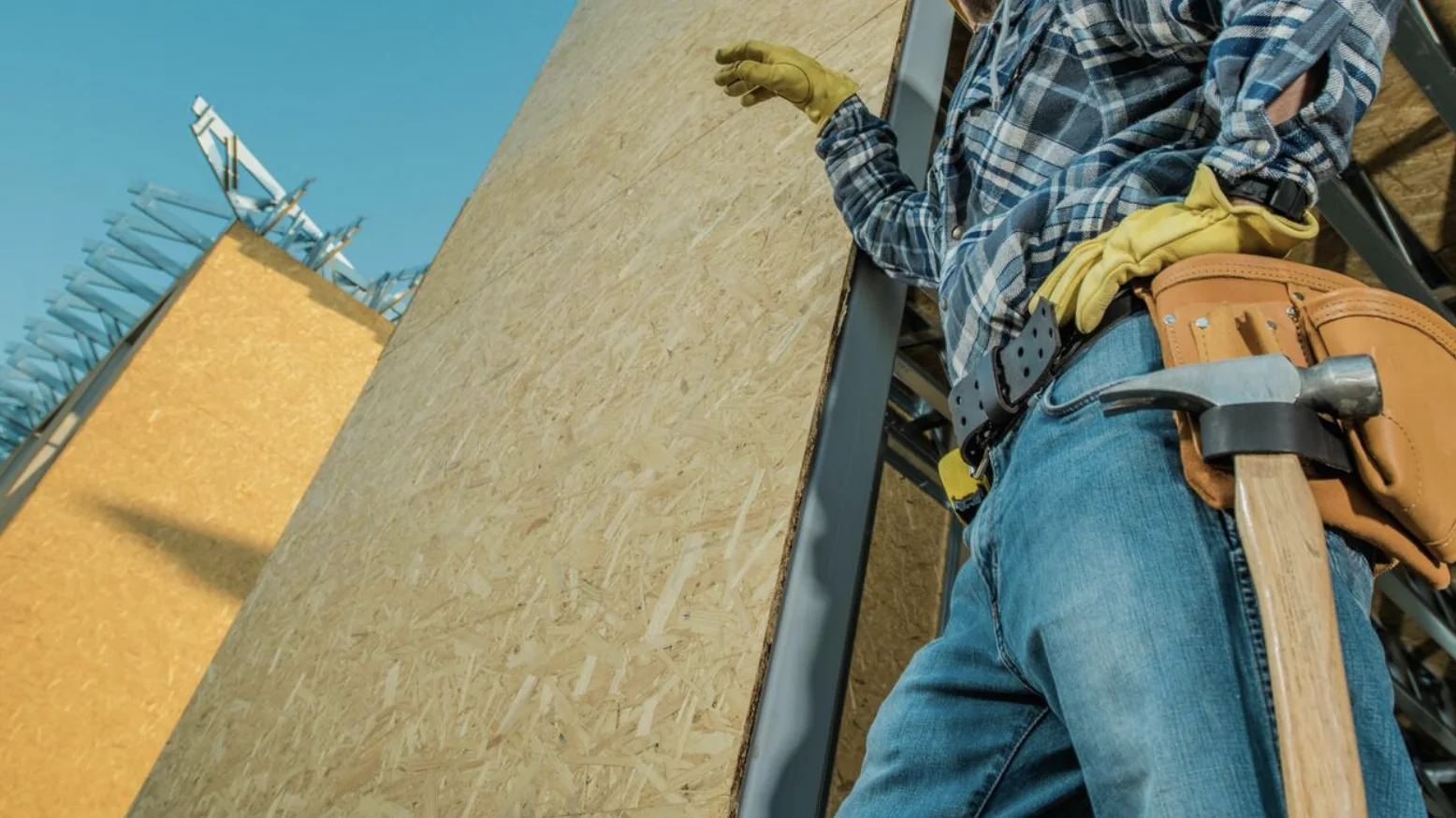 A construction professional working beside large structural panel walls